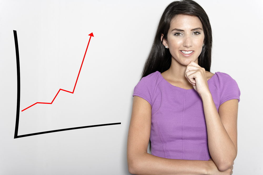 Professional working woman in corporate purple dress, with a concept graph displaying an increase.