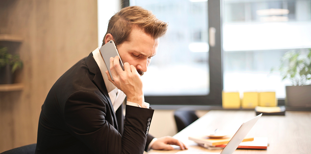 man-having-a-phone-call-in-front-of-a-laptop-859264